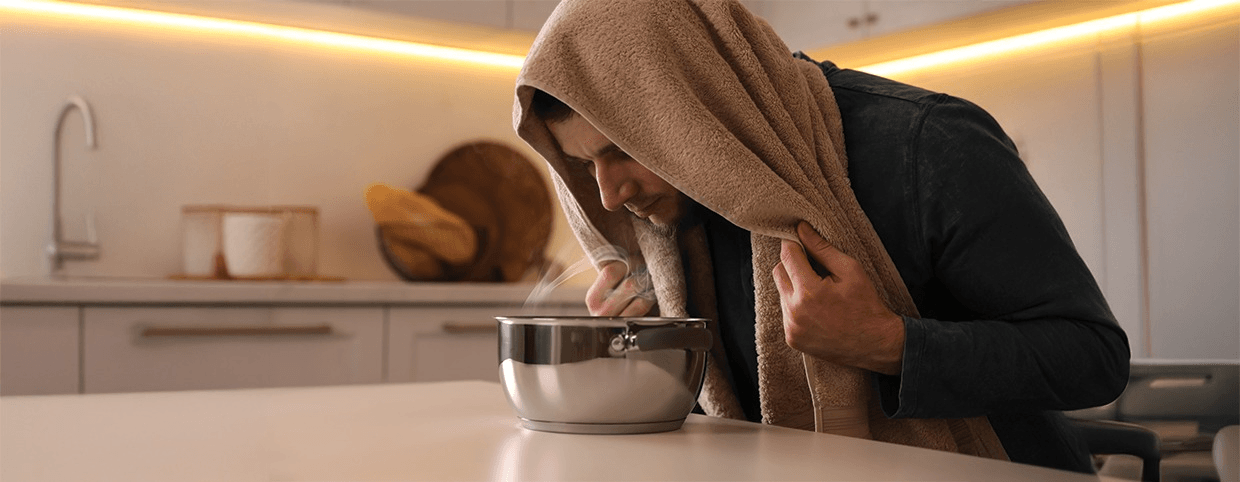 Man taking hot water vapour during his flu recovery